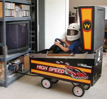 boy sitting in a pinball machine, playing Gran Turismo 3